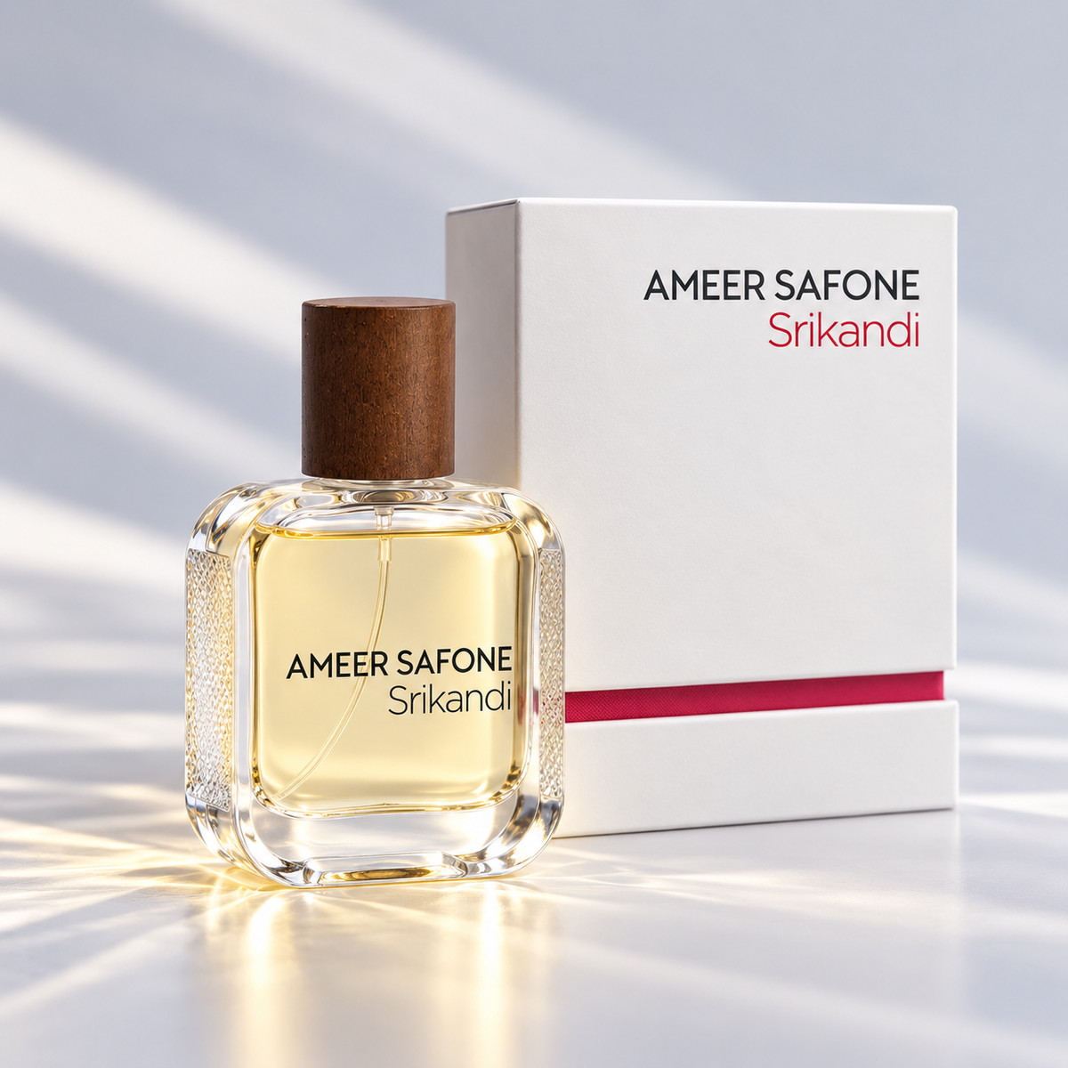 A bottle of Ameer Safone Srikandi perfume with a clear glass body, yellow-amber liquid, and a brown cap, shown next to its white box with black and red text on a softly lit surface.